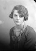 Ateljébild på en kvinna i halsband och klänning. Enligt Walter Olsons journal är bilden beställd av Elisabet Dahlström ifrån Mellsta by.
