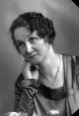 Ateljébild på en kvinna i halsband och klänning. Enligt Walter Olsons journal är bilden beställd av fru Elsa Lindgren.