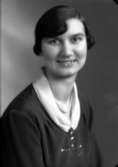 Ateljébild på en kvinna i halsband och klänning. Enligt Walter Olsons journal är bilden beställd av fröken Astrid Moberg.
