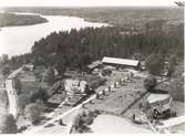 Flygfoto på Kristdala, Hule gård. Gården med ekonomibyggnader, grusvägen och sjön.