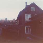 Ett gårdshus med sadeltak och träfasad.