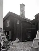 Ett bostadshus i träfasad på Norra Långgatan 56-58 i kvarter Mältaren 51.

Foto M.Hofrén 1932

T.v. nr 56 under rivning. Gårdssidan.
