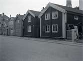 Bostadshus med träfasad och sadeltak på Norra Långgatan i kvarter kvarter Mältaren 31. Nummer 56 längst till höger rivet 1932.
