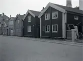 Bostadshus med träfasad och sadeltak på Norra Långgatan i kvarter kvarter Mältaren 31. Nummer 56 längst till höger rivet 1932.
