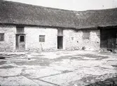 Gårdsexteriör med kalkstensladugård.