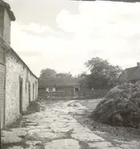 Bostadshus, ekonomibyggnad och stenläggning på marken i Folkeslunda.