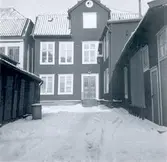 Baksidan av ett bostadshus med frontespis och mansardtak i kv. Rådmannen i Kalmar. Framsidan vetter mot Stortorget.