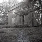 Byggnadens huvudfasad. Ett bostadshus med träfasad.