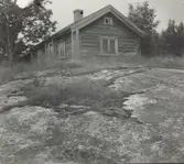 Ett bostadshus med korsknut och träfasad.