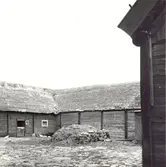 Ladugård i skiftesverk och med stråtak.