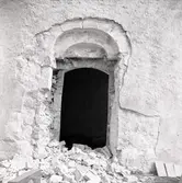 En dörromfattning i Voxtorp kyrka, med rasmassor framför.