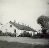 Bostadshus och barn vid buskar.