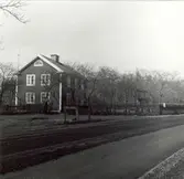 Ett bostadshus med lunettfönster och tomt med staket i Grönskåra.