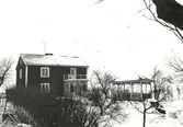 Östra sidan av landvägen från norr. Södra Vi, fastighetsbeteckning 1:11, Sjögärdet. Bostad med lusthus under vintertid.
