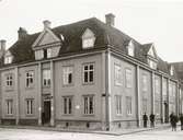 Ett bostadshus med träfasad. Har frontespis, takkupor och mansardtak. Orginalbild från 1908.