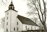 Odensvi kyrka med kyrkogården i förgrunden.