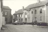 Bil och bostadshus med tegel och putsad fasad i kv Koljan.