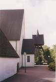 Mortorps kyrka med klockstapeln i bakgrunden.