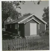 Moderniserad backstuga med ingång på gaveln.