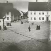 Stortorget fotograferat från apoteket Lejonet, före detta apoteket Kronan. På platsen för detta apotek står sedan 1964 Skandiahuset. Till höger i bild Svanholms hotell, Stadshotellets föregångare. Till vänster syns överbyggnaden på den allmänna vattenpumpen.