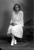Ateljébild på en kvinna i klänning. Enligt Walter Olsons journal är bilden beställd av Asta Adén.