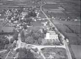 Flygfoto över Vickleby. Samhället med kyrkan hus och landsvägen.