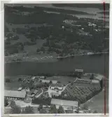 Flygfoto över Blankaholm i Hjorted. Samhället med bostäder, ekonomibyggnader och skärgården.