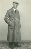 En man i hatt och kappa.