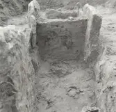 Hällkista från Neolitikum. Profil från norr med kolfläckar efter skelettet. I förgrunden skelettdelar.