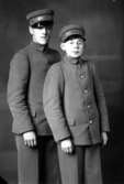 Ateljébild på en man och pojke i uniform och mössa där det står Stadshotellet. Enligt Walter Olsons journal är bilden beställd av Folke Karlsson.