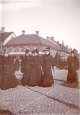 Kvinnor i klänning och hatt på Larmtorget.