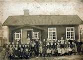 Flohultsläraren K.M. Karlén framför Falla skola omkring år 1900.