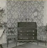 Korparyd.  Interiör av salen. Snedklaffbyrån med intarsia är utfört i ett snickeriarbete, som synes vara ganska vanligt i socknen.