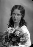 Ateljébild på en kvinna som håller en blombukett. Enligt Walter Olsons journal är bilden beställd av Dagmar Bohman.