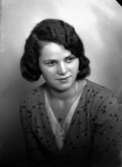 Ateljébild på en kvinna i halsband och ondulering. Enligt Walter Olsons journal är bilden beställd av Sonja Andersson.