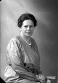 Ateljébild på en kvinna i klänning och pärlhalsband. Enligt Walter Olsons journal är bilden beställd av fru Wirén.