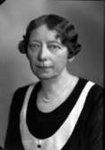 Ateljébild på en kvinna i halsband och klänning. Enligt Walter Olsons journal är bilden beställd av fröken Anny Melén.