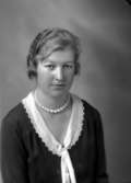 Ateljébild på en kvinna i halsband och spetskrage. Enligt Walter Olsons journal är bilden beställd av Anna Karlsson.
