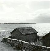 Sjöbod uppförd i sten och med stråtak i Djupvik.