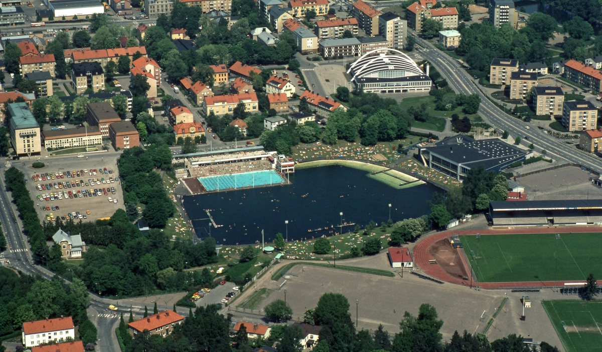 Flight view of the Tinner basin a hot summer day. Bathing Place. Swimming Hall. Tinnis. Folkungavallen Bathing. The Tinner Basin was opened on 19 June 1938. The final design of the plant was created by the city architect Sten Westholm. The time-typical entrance, dressing and restaurant building is largely untouched since its construction. The driving political force behind the bath was the merchant Axel Brunsjö. In some circles, the Bath was called Brunsjö, after the merchant’s great commitment to the Bath.