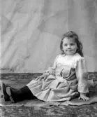 Ateljébild av flicka på golv.