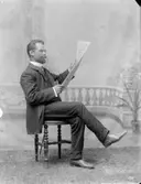 Ateljé. 
Tidningsläsande herre. 
Fotograf: Ellen Kock? Axel Lundbäck m.fl. 
Gullspångssamlingen.
Bilder från Gullspång med omnejd.