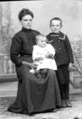 Ateljé. Dam med barn i knäet och en pojke. Fotograf: Ellen Kock? Axel Lundbäck m.fl.Gullspångssamlingen.Bilder från Gullspång med omnejd.