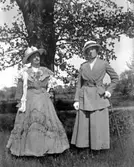 Maria Berg och jungfrun Augusta Johansson i nysydda kläder av sömmerskan Agda Zetterman, dotter till smeden Zetterman, som bodde inom Prinshaga o Ökulls ägor.

Kapten Sigge Flachs samling, Prinshaga, Axvall.

Fotograf: Maria Berg, född Flach.