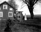 Maria Berg bär sin dotter Marie-Louise på armen, hennes man Knut Berg och jungfrun Augusta Johansson utanför Knutstorp.

Marie-Louise Berg, gift Grauers, f. 1914.

Kapten Sigge Flachs samling, Prinshaga, Axvall.