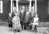 John och Jenny Johansson. 
Stugan i Harstensmossen, som de står framför, byggdes 1934 på samma plats som den tigare stugan låg. Fotot är tagit 1936 då dottern Astrid var 1 år, det är hon som sitter i sin mammas knä. John föddes i den gamla stugan 15Feb 1895.
Jenny föddes i Lofalla Halna 12Okt 1890. John och Jenny gifte sej 23April 1916, de träffades då de båda arbetade på Boda gård vid sjön Viken. John och Jenny fick nio barn äldsta sonen Gunnar f 1915 dog då han var 20 månader i tuberkulos. 
De större sönerna i bakre raden är från vänster:
Holger f 1923, Gustav f 1918, Karl Erik f 1920. 
De mindre pojkarna på främre raden från vänster:
Einar f 1929, Nils f 1925, Axel f 1927. 
I Jennys knä sitter dottern Astrid f 1935 och i Johns knä sitter dottern Ingrid f 1931.