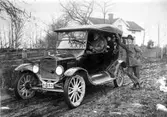 I bilen: Karl Andersson, son till Alfred Andersson, Skaga, vars ställe 
syns i bakgrunden (numera Torgny Karlssons).
Bredvid: Einar Andersson (bror).
Bilen tillhör David Karlsson.
Karl Andersson hade affär vid Korsvägen på 1920-talet. 
Flyttade till Väring.

Reprofotograf: Gunnar Berggren.