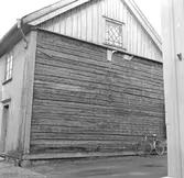 Skara. 
Kvarteret Jupiter. Tomt nr. 11.
Gatufastigheten Skolgatan 17.
Östra gaveln sedan brädfodringen avlägsnats.