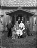 Exteriör. 
Fyra damer sittande vid bord flankerade av två herrar framför hus med veranda. 
Gullspångssamlingen. 
Bilder från Gullspång med omnejd.