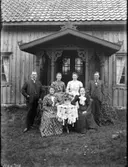 Exteriör. 
Fyra damer sittande vid bord flankerade av två herrar framför hus med veranda. 
Gullspångssamlingen. 
Bilder från Gullspång med omnejd.